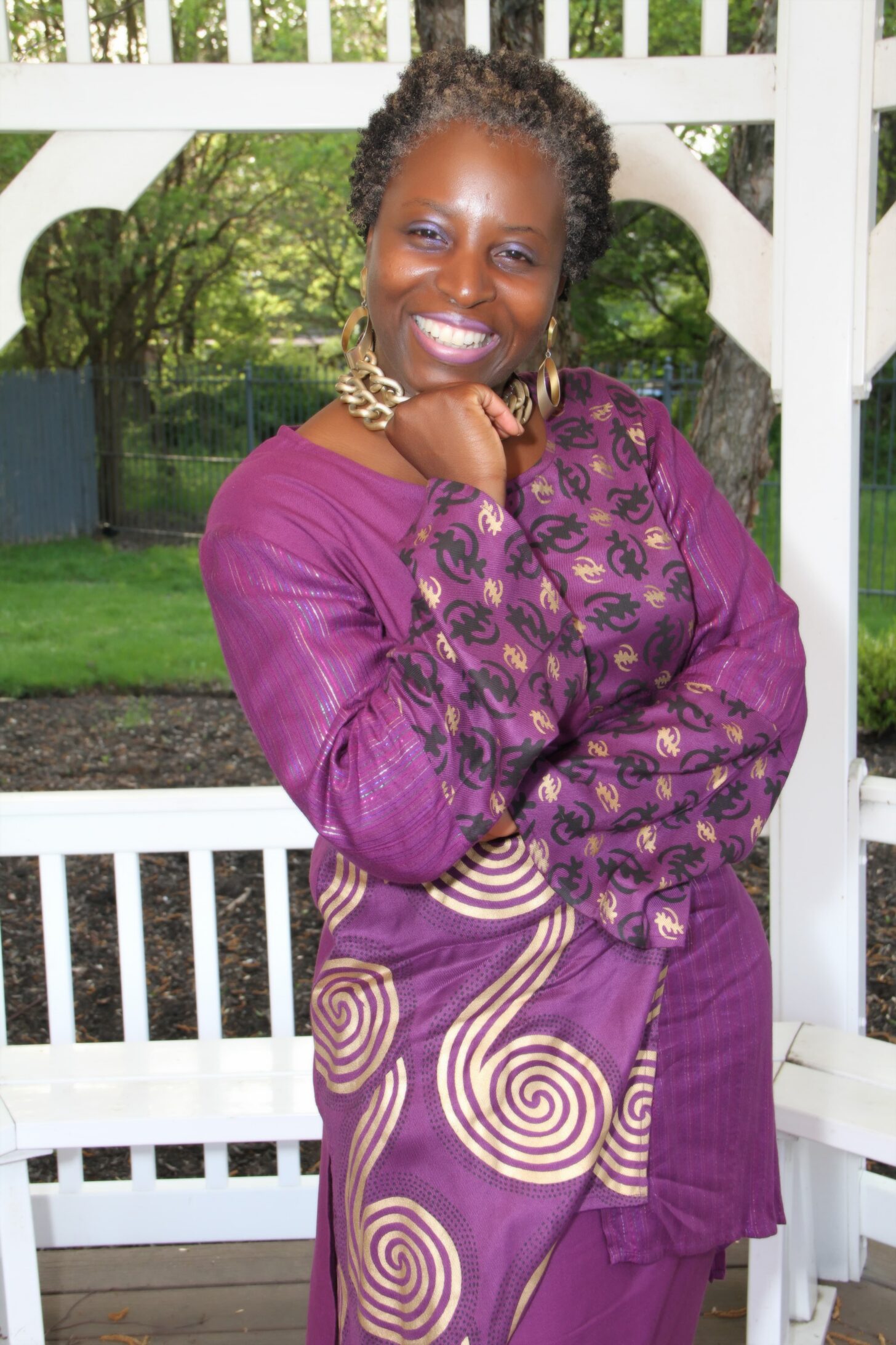 Smiling woman in purple patterned dress posing